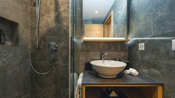 A modern bathroom with a freestanding bathtub, a sink with a vessel basin, and a wooden vanity.