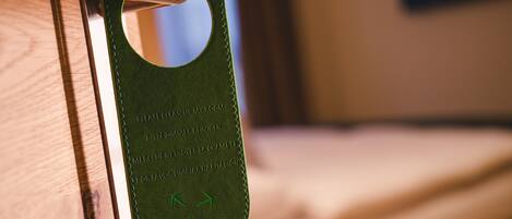 A door with a green mat that has instructions in multiple languages to clean up the room.