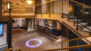 A hotel lobby with a bar area, a staircase, and a large compass floor design. - Hotel Tannenhof (Zermatt)