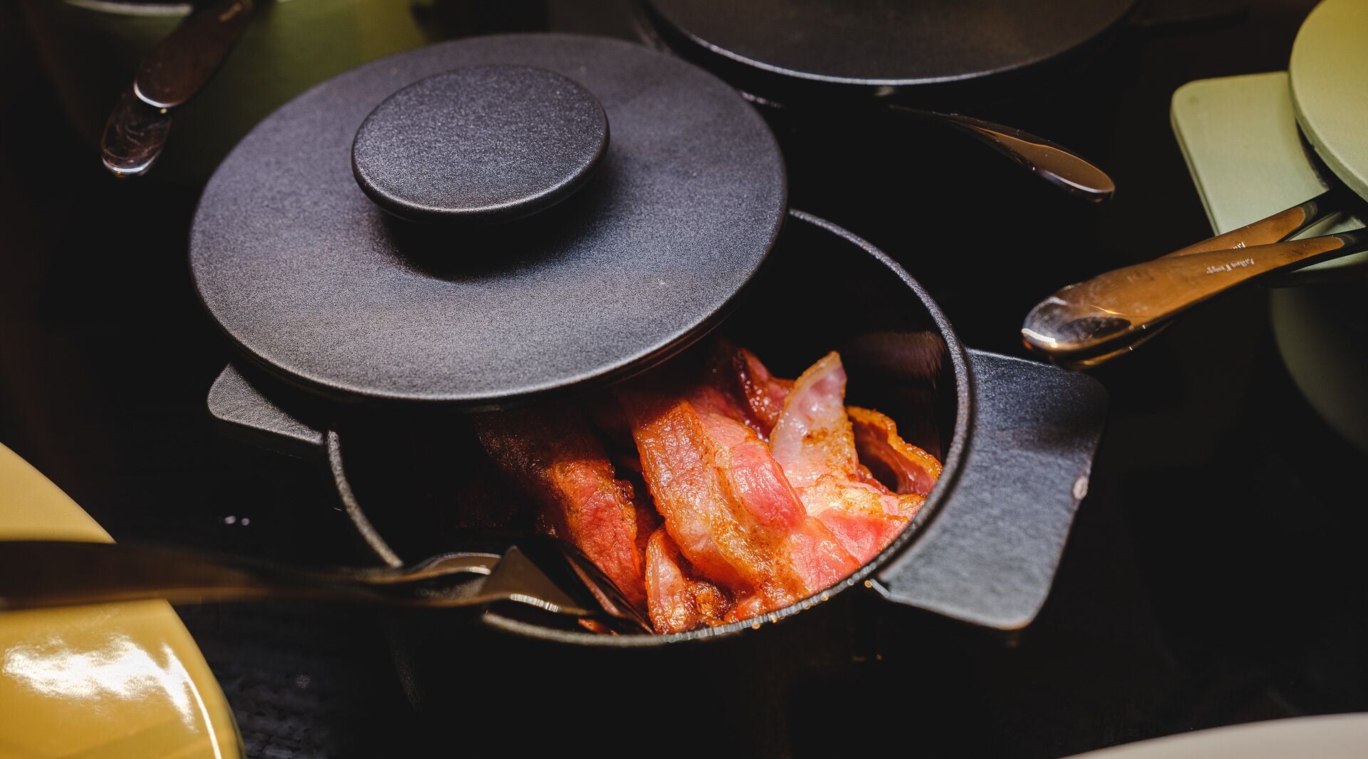 A kitchen with a pot containing bacon.