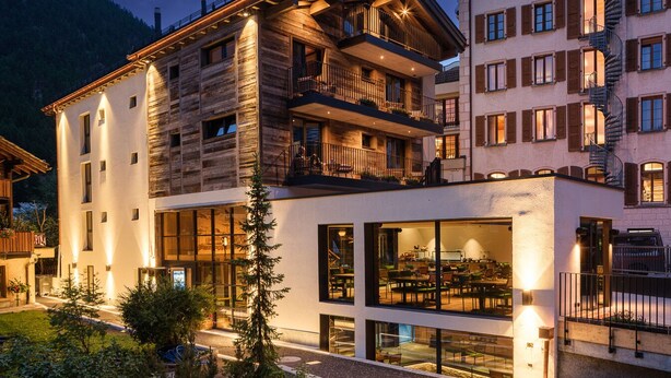 A multi-story hotel with a modern design, featuring balconies and large windows. - Hotel Tannenhof (Zermatt)