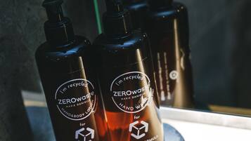 Three bottles of hand wash soap on a wooden surface.