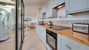 A modern kitchen with light blue cabinets, a wooden countertop, a built-in oven, and a toaster. - 2 Bed in Dartmouth (oc-bc42ab) (Dartmouth)