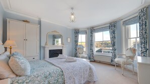 A bedroom with a bed, a fireplace, a chair, and a view of the outside. - 2 Bed in Dartmouth (oc-bc42ab) (Dartmouth)