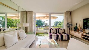 A modern living room with a sofa, a glass coffee table, and a television.