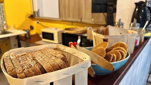 A kitchen counter with bread and cookies.