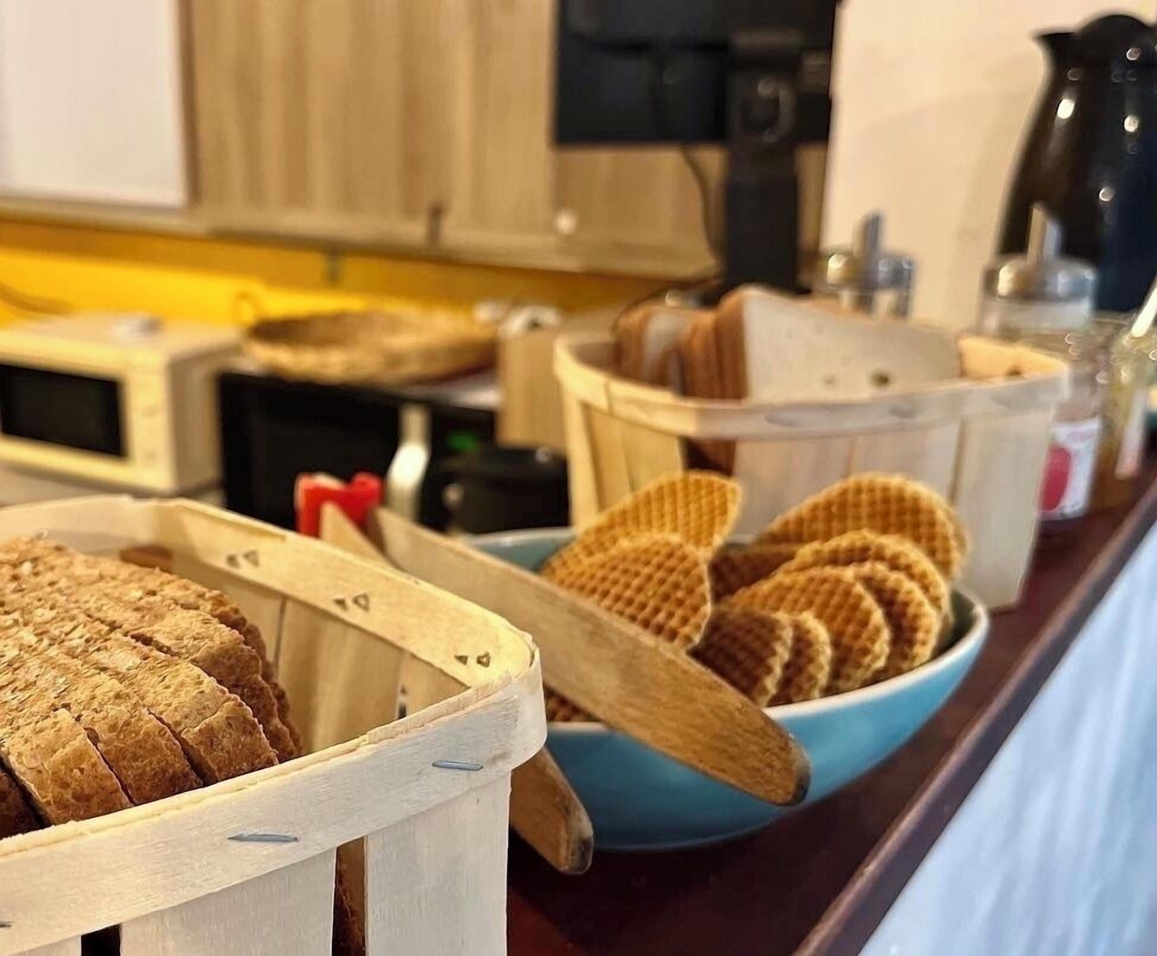 A buffet with various food items including bread and waffles.