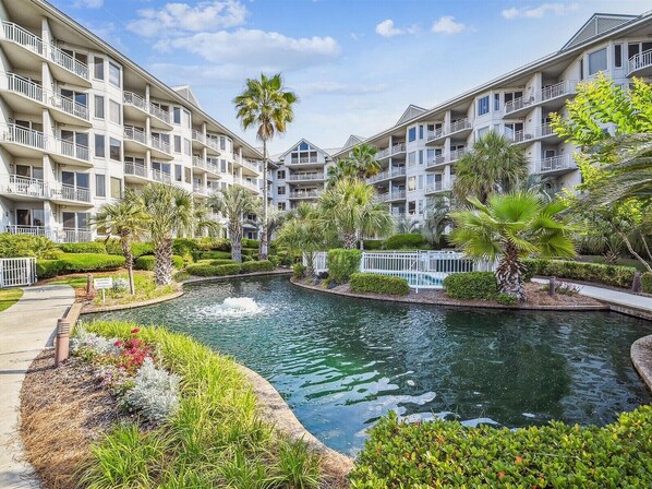 A resort with multiple-story buildings, a central water feature, and well-maintained landscaping.