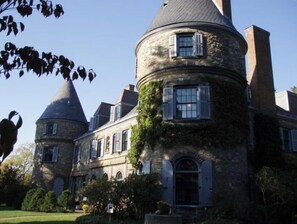 Experience the charm of traditional European architecture in this historic building, featuring a central round tower and arched windows.