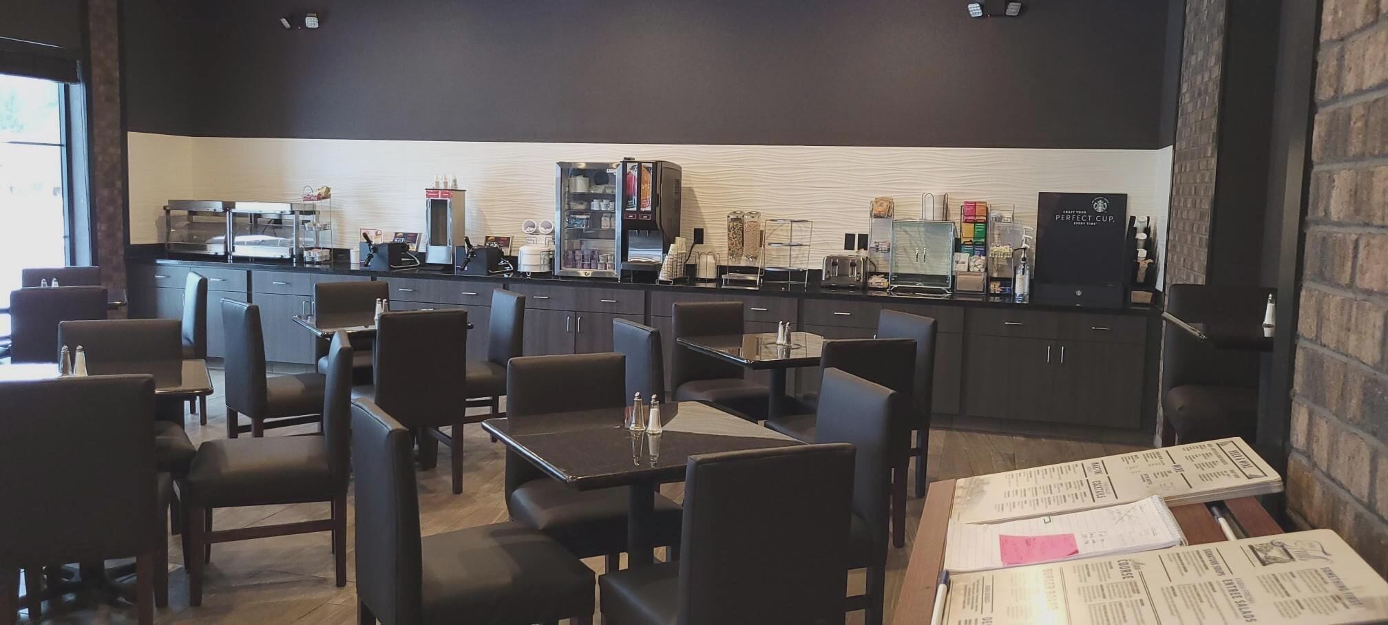 A restaurant with booths and tables, a coffee machine, and a menu on the table.