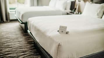 Ein Hotelzimmer mit zwei Betten, einem Schild, das auf das Rauchverbot hinweist, und einem Teppichboden.