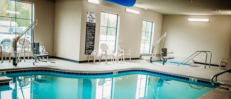 A swimming pool with chairs and a lifeguard stand.