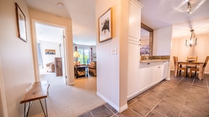 A spacious kitchen with a dining area, a small table, and a kitchen island. - 2-Bedroom 2-Bathroom Condo with Mountain Views (Radium Hotsprings)