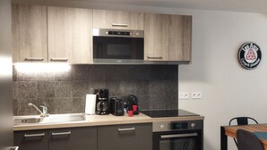 A modern kitchen with dark cabinets, a microwave, a coffee maker, and a toaster. - ARC 1800 apartment 6-8pers with garage all comfort (Bourg-Saint-Maurice)