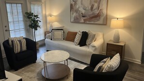A living room with a sofa, two armchairs, a coffee table, and a lamp. - Fabulous 3 bedroom/2 bath with attached Garage (Alpharetta)