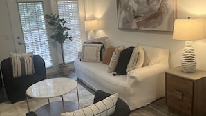 A modern living room with a sofa, armchairs, a coffee table, and a painting on the wall. - Fabulous 3 bedroom/2 bath with attached Garage (Alpharetta)