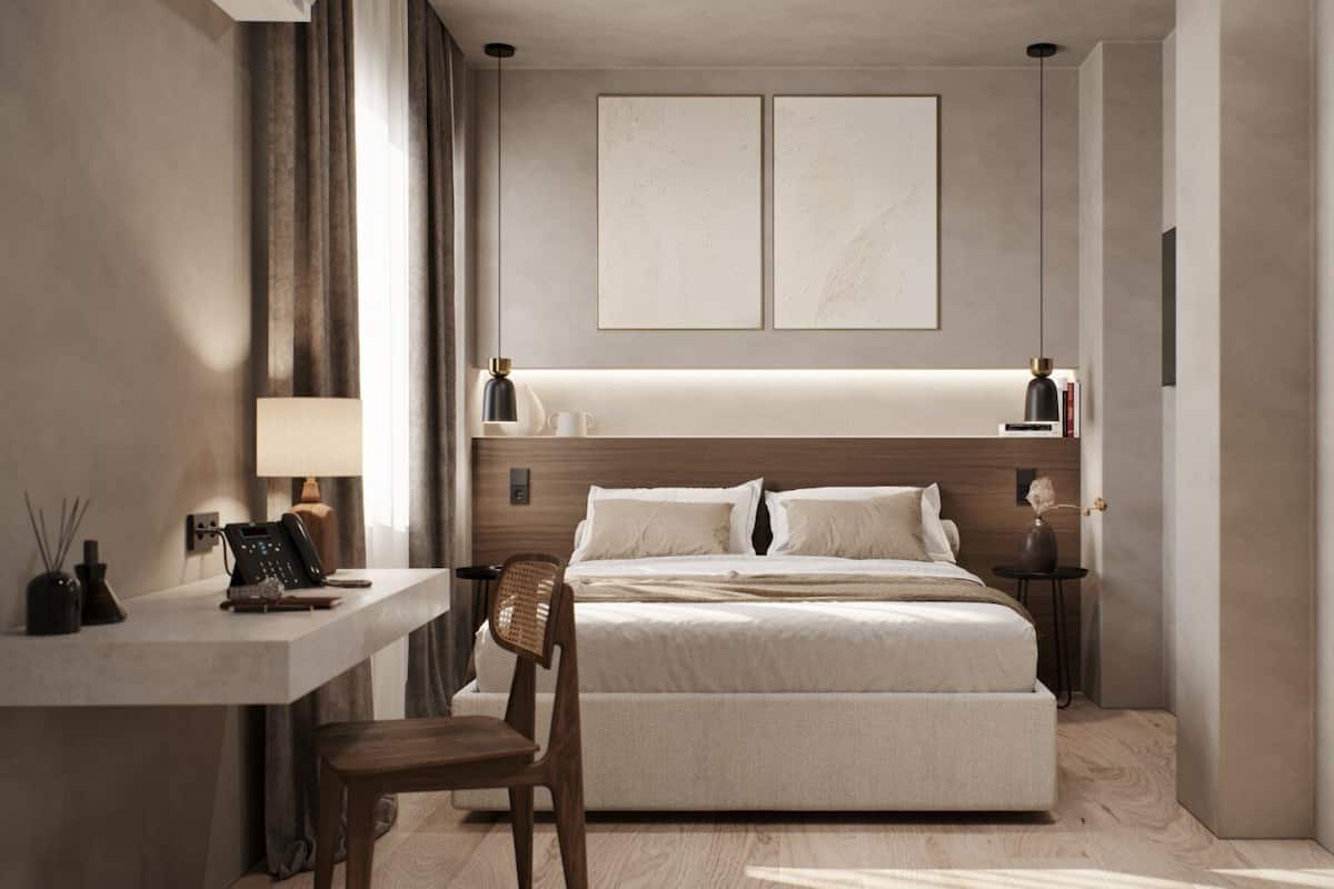 A modern hotel bedroom with a large bed, bedside tables, a desk, and a chair.