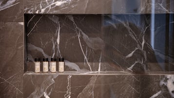 A marble shelf with four bottles of olive oil.