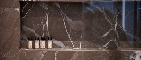 A marble shelf with four bottles of olive oil.