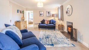 A living room with a sofa, rug, fireplace, and wall art.