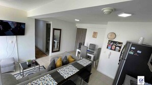A modern apartment with a dining area, a living room, and a kitchen.