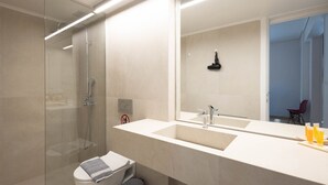 A modern bathroom with a glass shower enclosure, a large mirror, and a white sink. - Elegant Retreat in Kolonaki - Renovated April 2026 (Athens)