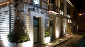 A building with a sign reading "WHITE" and two potted plants at the entrance. - Residenze Romano Albergo diffuso & spa (Foggia)