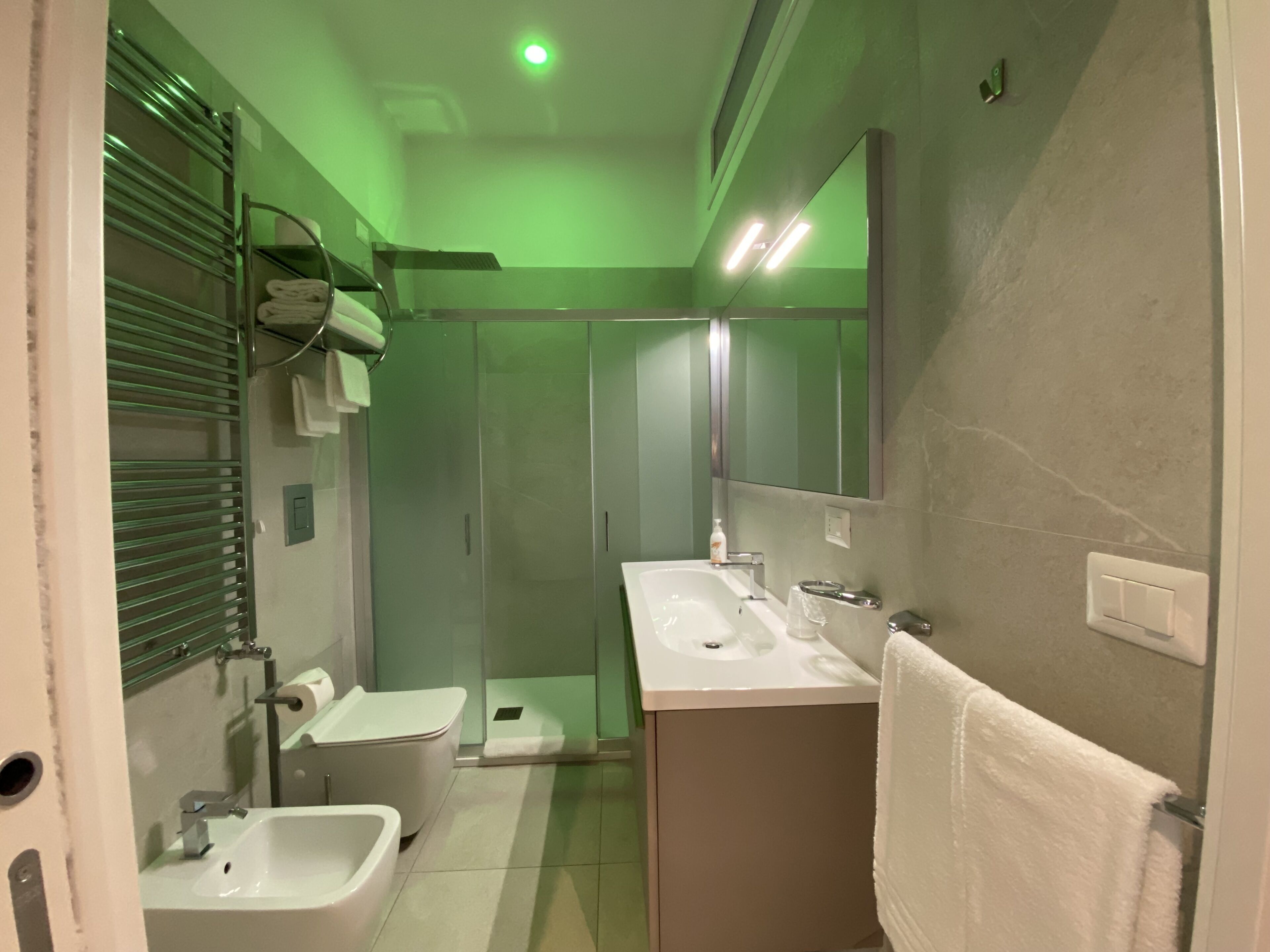 A modern bathroom with a glass shower enclosure, a white sink, and a bathtub.