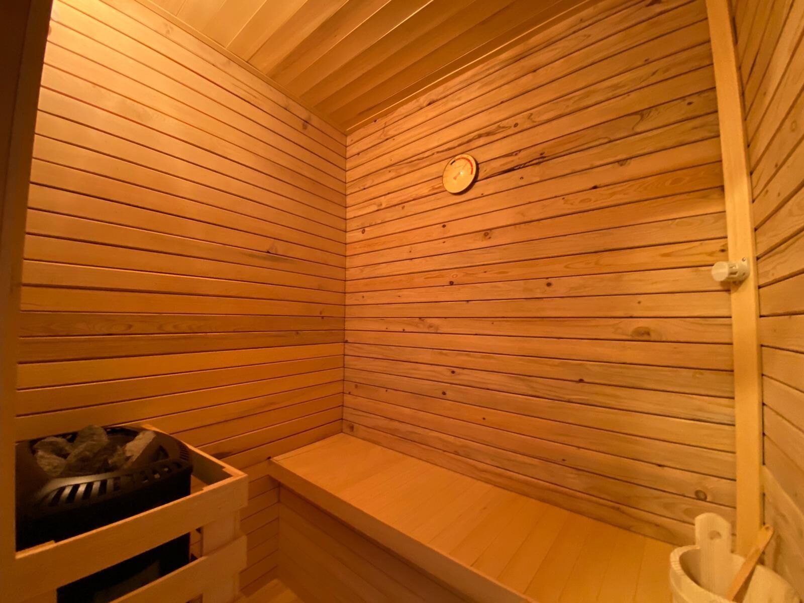 Un sauna avec des parois en lambris de bois et un banc.