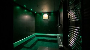 A dimly lit room with green ambient lighting, a tiled floor, and a small wall-mounted light fixture. - Residenze Romano Albergo diffuso & spa (Foggia)