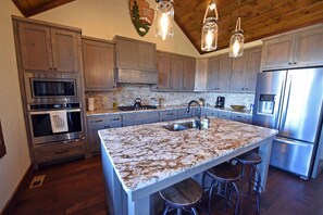 A kitchen with granite countertops, stainless steel appliances, and wooden cabinets.