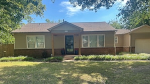 A single-story house with a front porch, a garage, and a brick foundation. - Stunning home in the middle of midtown close to fairgrounds. (Tulsa)