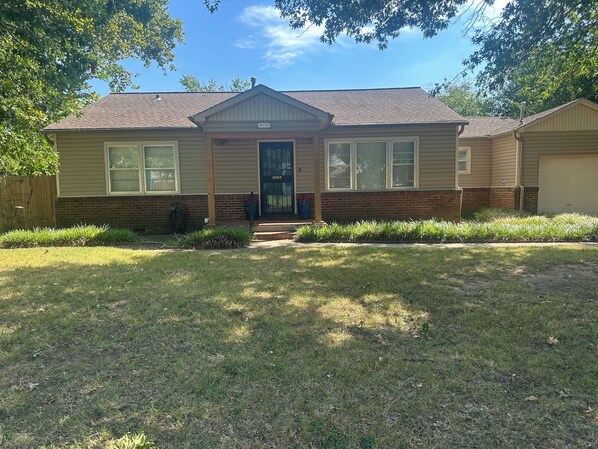 A single-story house with a front porch, a garage, and a brick foundation. - Stunning home in the middle of midtown close to fairgrounds. (Tulsa)
