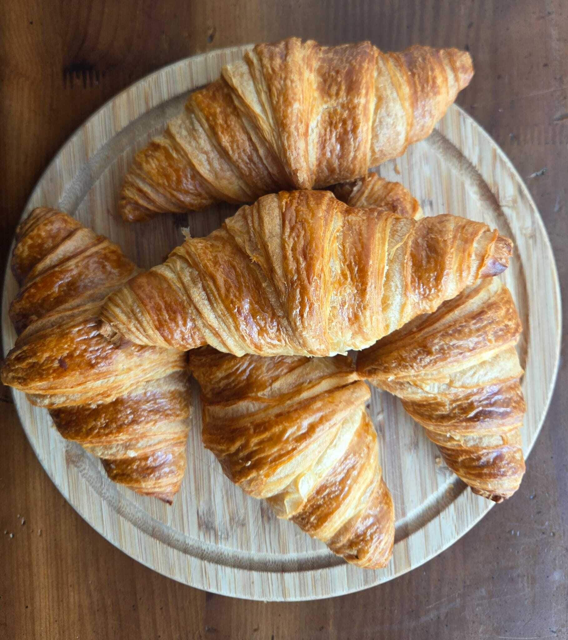 A wooden plate with croissants.