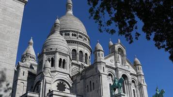 A large, historic building with multiple domes and statues.
