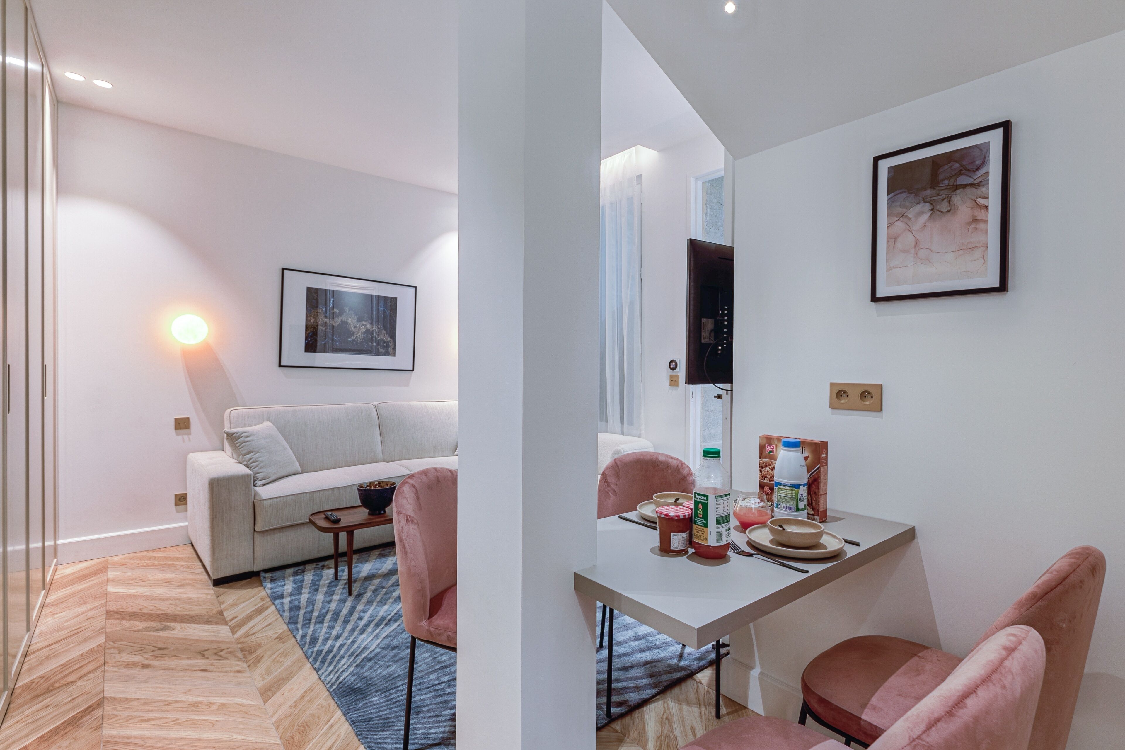 Een moderne woonkamer met een bank, een salontafel en een eethoek met een tafel en stoelen.
