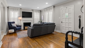 A living room with a sofa, armchair, and a fireplace.