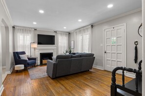 Uma sala de estar com sofá, poltrona e lareira.