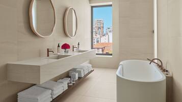 Un baño moderno con una bañera grande, un tocador con doble lavabo y dos espejos.