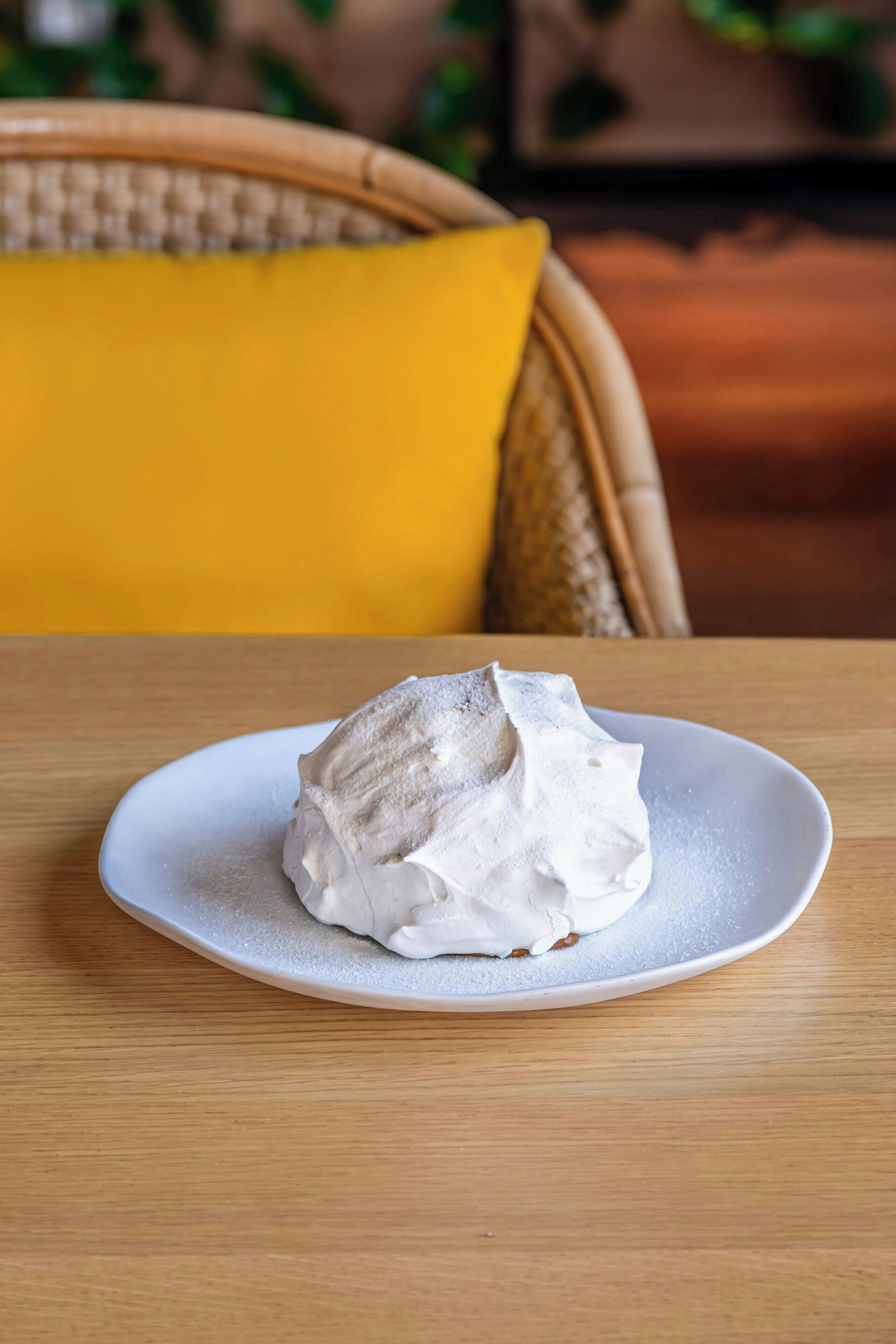 Un plato blanco con un postre sobre una mesa de madera.