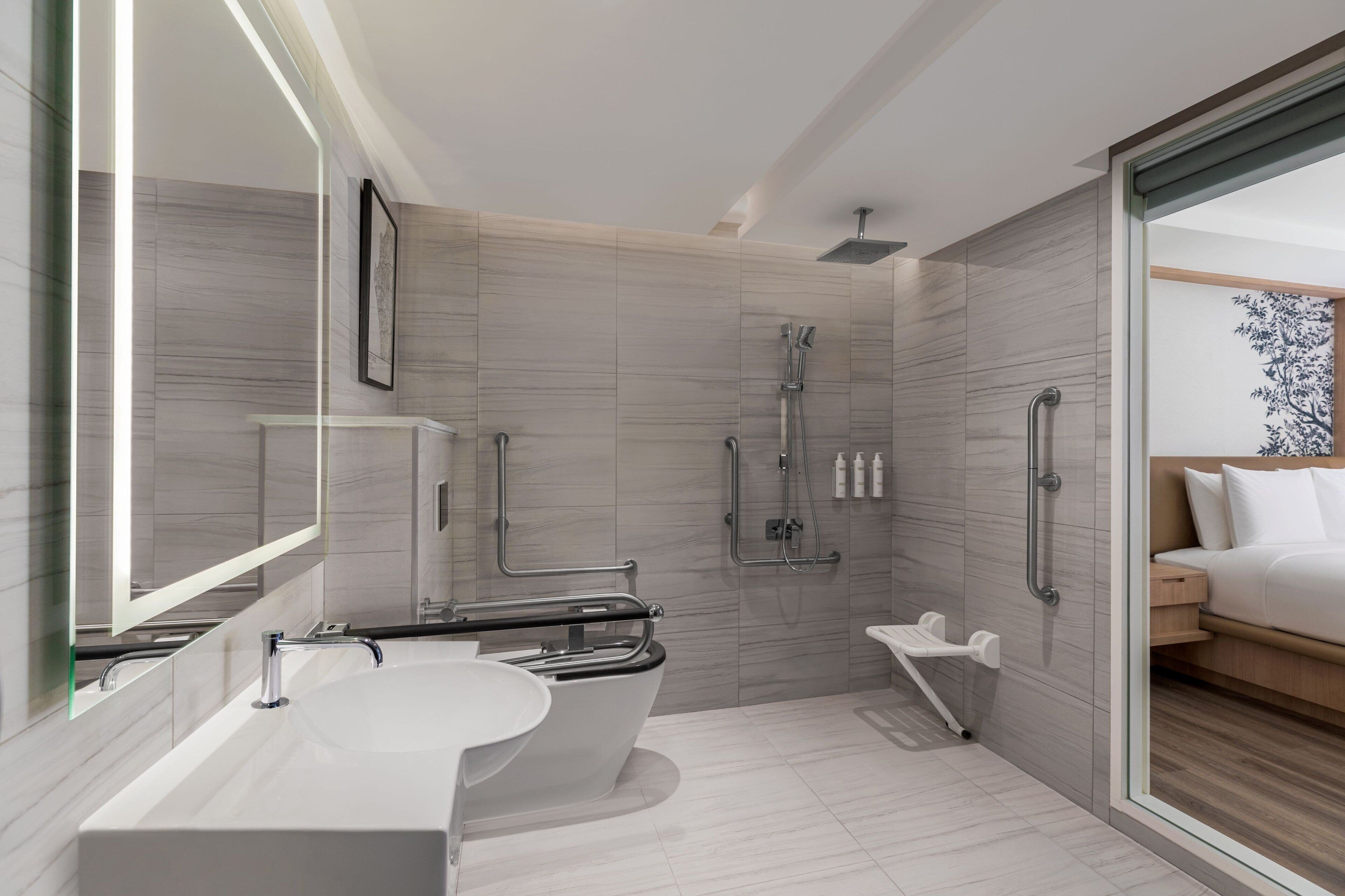 Un baño moderno con una bañera independiente, una ducha a ras de suelo y un área de ducha con cerramiento de vidrio.