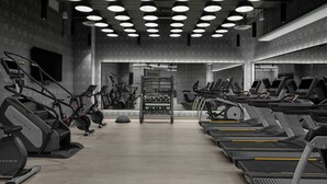 A modern gym with treadmills, stationary bikes, and weight machines. - The Dorian, Autograph Collection (Calgary)
