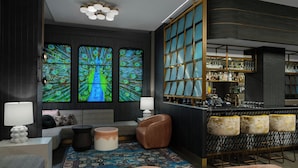 Un bar moderno con un ventanal con motivos de pavo real, una zona de estar con un tapete estampado y una barra con taburetes.