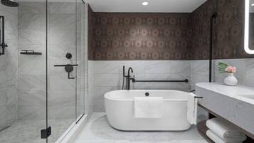 Ein modernes Badezimmer mit einer freistehenden Badewanne, einer gläsernen Dusche und einem Boden aus Marmor.
