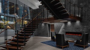 Een modern interieur met een houten trap, een open haard en een zithoek.