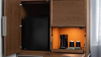 Una cucina con macchina del caffè integrata e frigorifero nero.