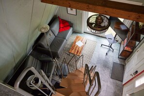 A spacious living area with a sofa, coffee table, and dining table.