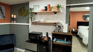 A compact kitchen with a stove, refrigerator, and wooden cabinet. A microwave and a coffee maker are also visible. - Private getaway in a beautiful neighborhood (Salem)