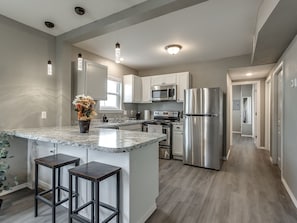 Een moderne keuken met een centraal eiland, roestvrijstalen apparatuur en een minimalistisch design.