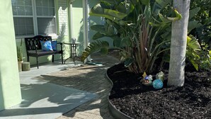 A house with a porch, a bench, and a potted plant.